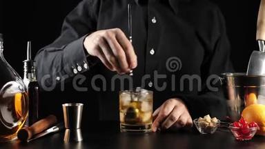 老式鸡尾酒。 调酒师用调酒师的勺子把糖、糖、冰块和波旁威士忌混合在玻璃杯中